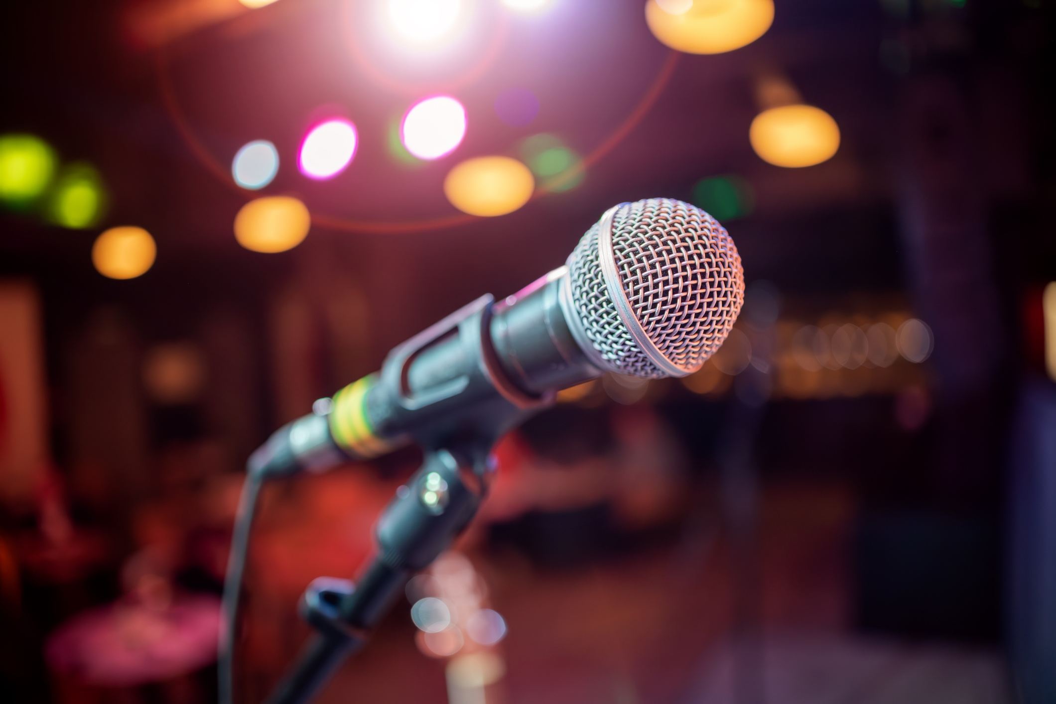 Microphone on stage against a background of auditorium. Public performance on stage Microphone on stage against a background of auditorium. Shallow depth of field.